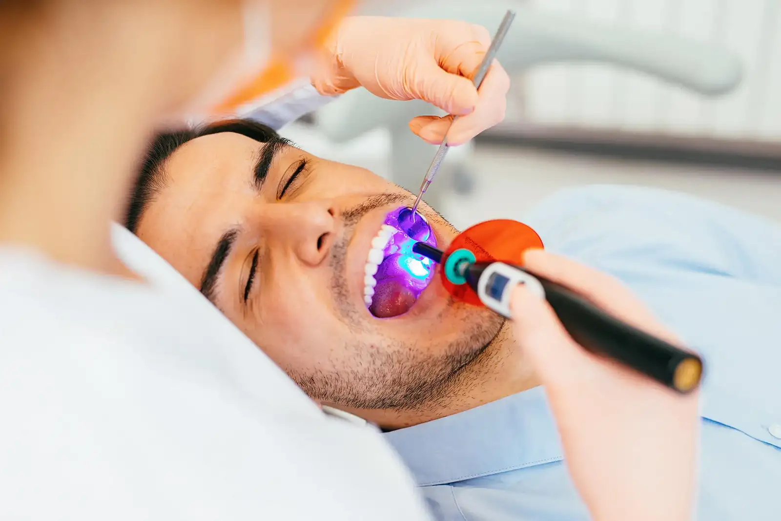 Dental professional applying restorative material to a tooth
